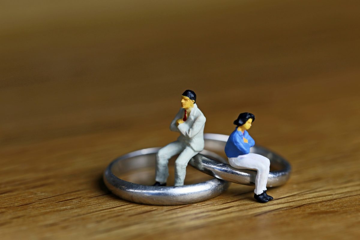 結婚指輪の上に乗る夫婦の人形